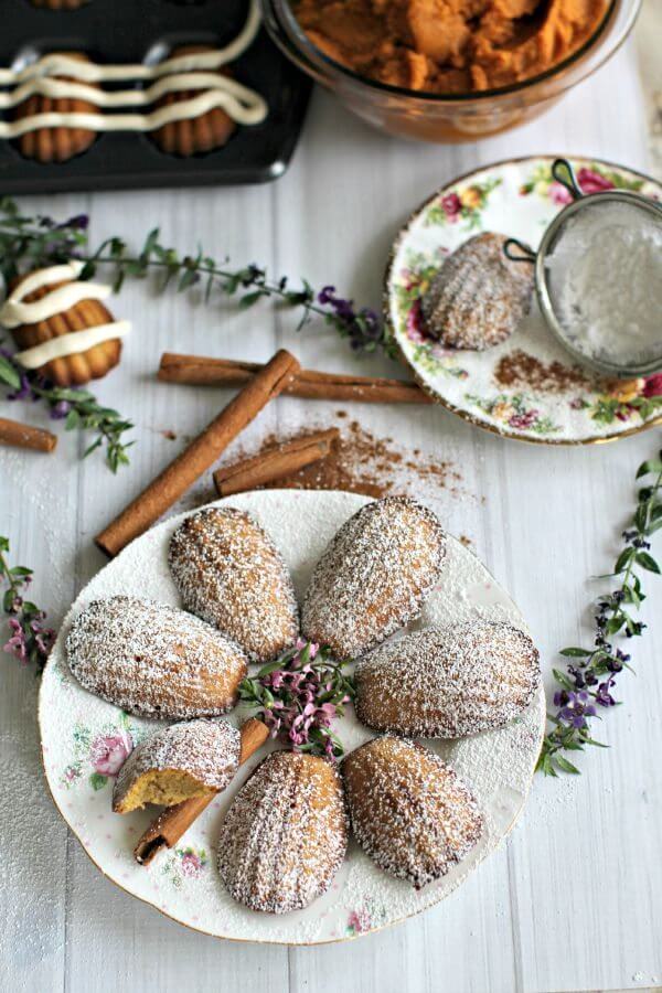 pumpkin madeleines with cinnamon sticks on the side on a white table