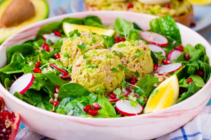 Tuna salad with avocado on top of spinach salad.