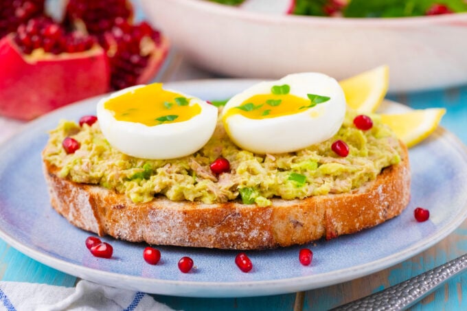 Avocado tuna salad sandwich topped with a runny egg.