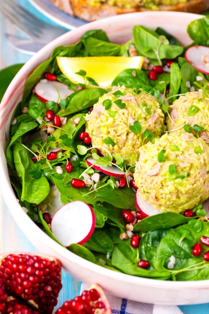 Spinach salad topped with mayo-free, creamy, avocado tuna salad.
