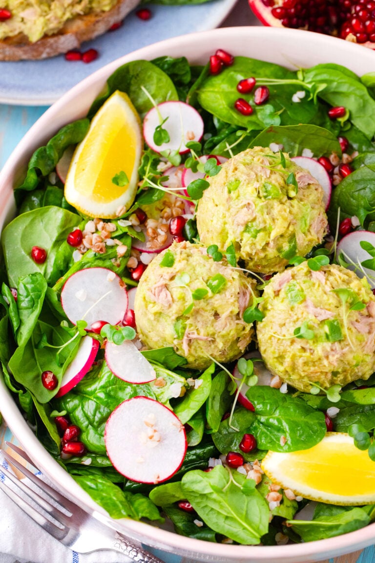 Spinach salad topped with mayo-free, creamy, avocado tuna salad with radishes.