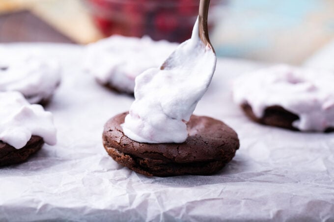 Topping chocolate donuts with raspberry coconut cream.