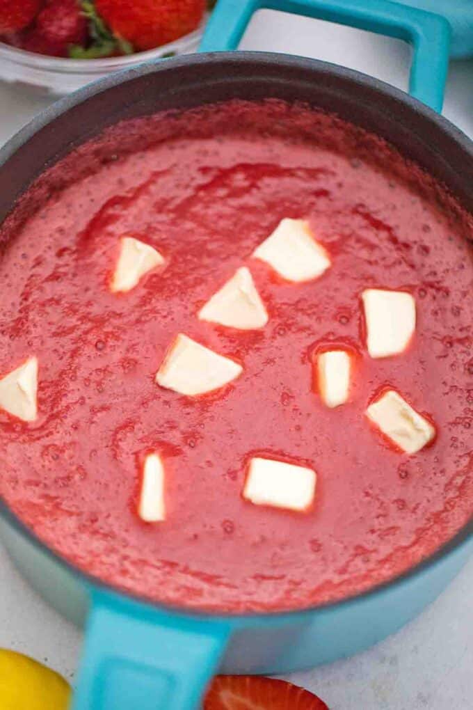 adding butter to strawberry curd