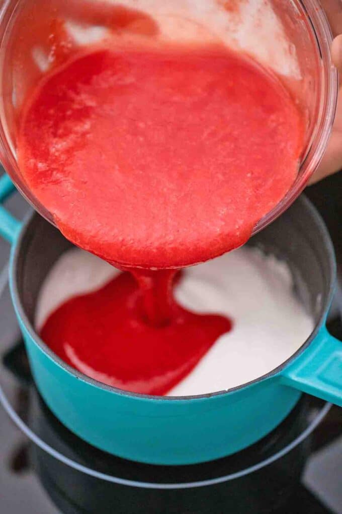 adding strawberry puree to a saucepan with cornstarch