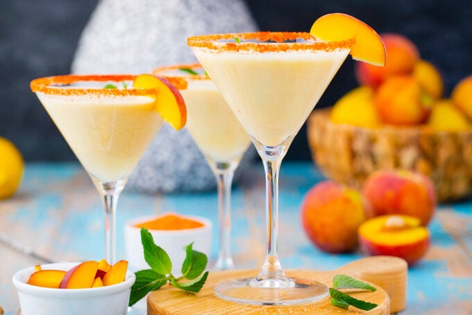 Peaches and cream martini garnished with peach slices.
