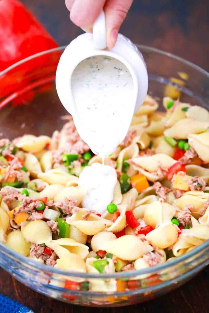 adding dressing to tuna pasta salad