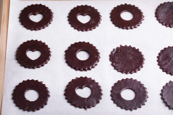 Chocolate Linzer cookies on a baking sheet.
