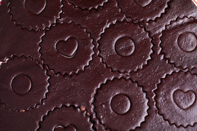 Cutting Linzer cookie shapes into chocolate dough.