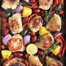 One Sheet Pan Mediterranean Chicken with olives, capers, red onion, red pepper and grape tomatoes in a fresh lemon orange honey sauce. A hearty, easy meal!