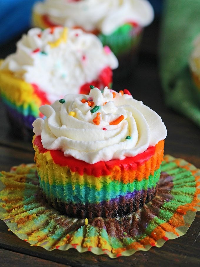 Mini Rainbow Cheesecakes topped with fluffy whipped cream