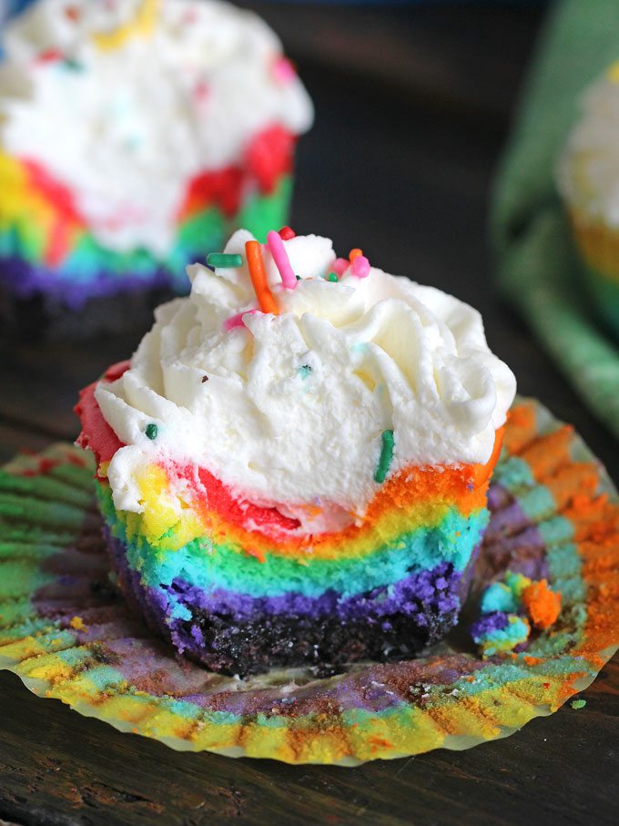 Mini Rainbow Cheesecakes topped with whipped cream and sprinkles