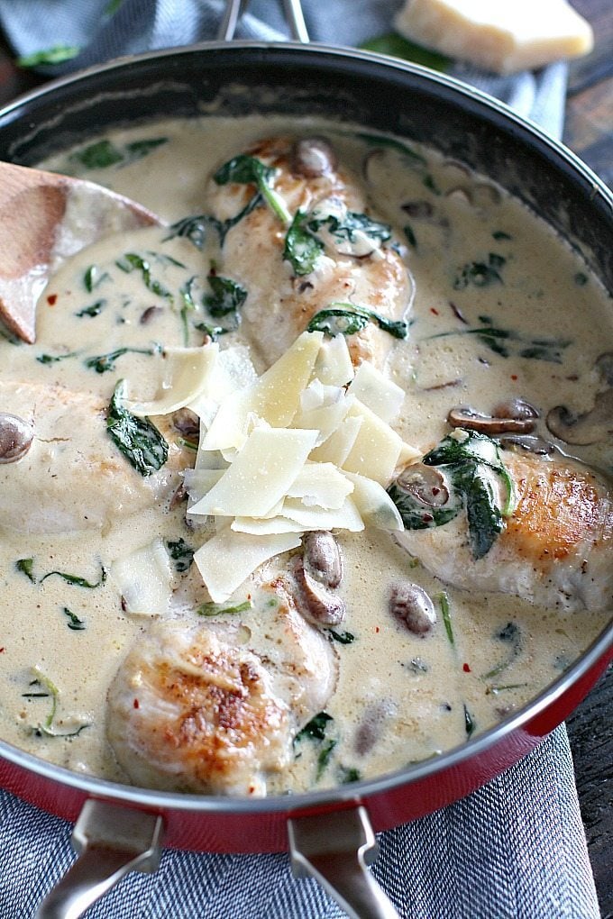 creamy parmesan mushroom chicken in a pan topped with shaved parmesan