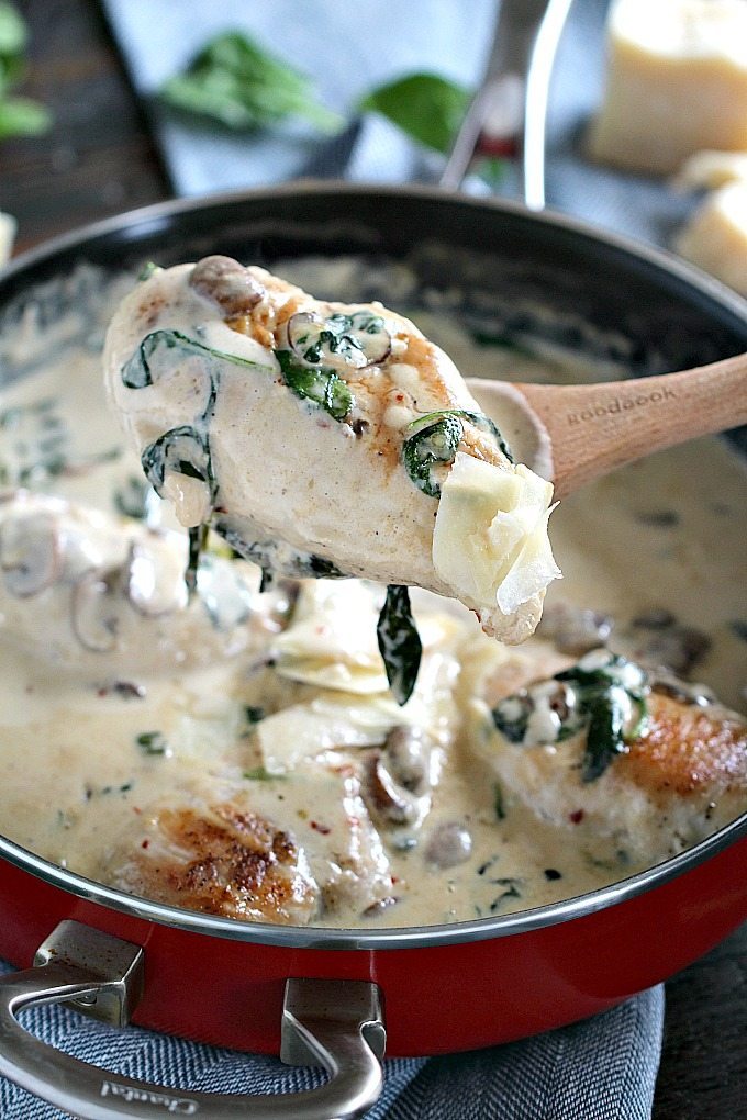 a browned chicken breast in a creamy parmesan sauce with spinach