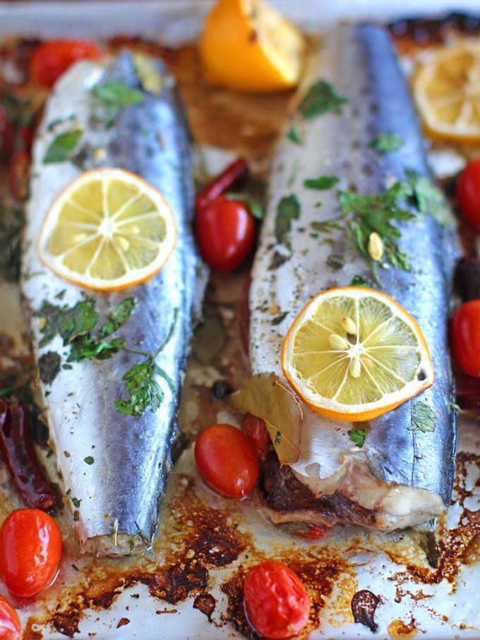 Two oven-roasted Spanish mackerel marinated with grape tomatoes, capers, dried chili peppers, and lemon.