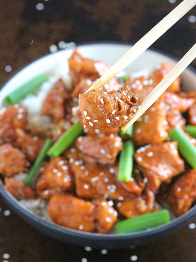 chopsticks holding a piece of mongolian chicken