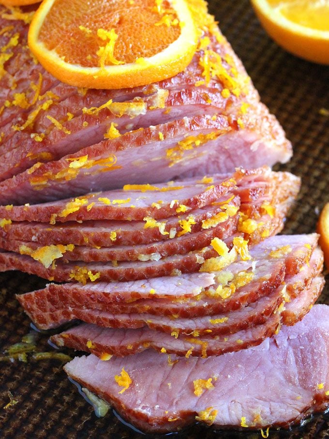 Picture of sliced brown sugar ham topped with orange glaze. 