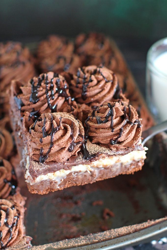 a slice of homemade German chocolate poke cake on a serving spatula