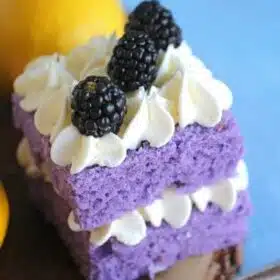 Vanilla Purple Cake with Lemon Buttercream is cut into mini individual cakes decorated with fresh blackberries, for a beautiful and tasty dessert.