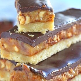 Homemade Snickers Bars are very easy to make and melt in your mouth with deliciousness. Buttery shortbread, caramel with crunchy peanuts and chocolate!