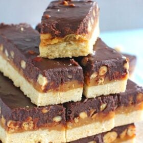 Homemade Snickers Bars are very easy to make and melt in your mouth with deliciousness. Buttery shortbread, caramel with crunchy peanuts and chocolate!