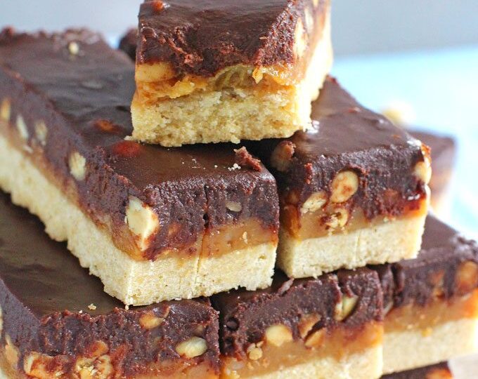 Homemade Snickers Bars are very easy to make and melt in your mouth with deliciousness. Buttery shortbread, caramel with crunchy peanuts and chocolate!