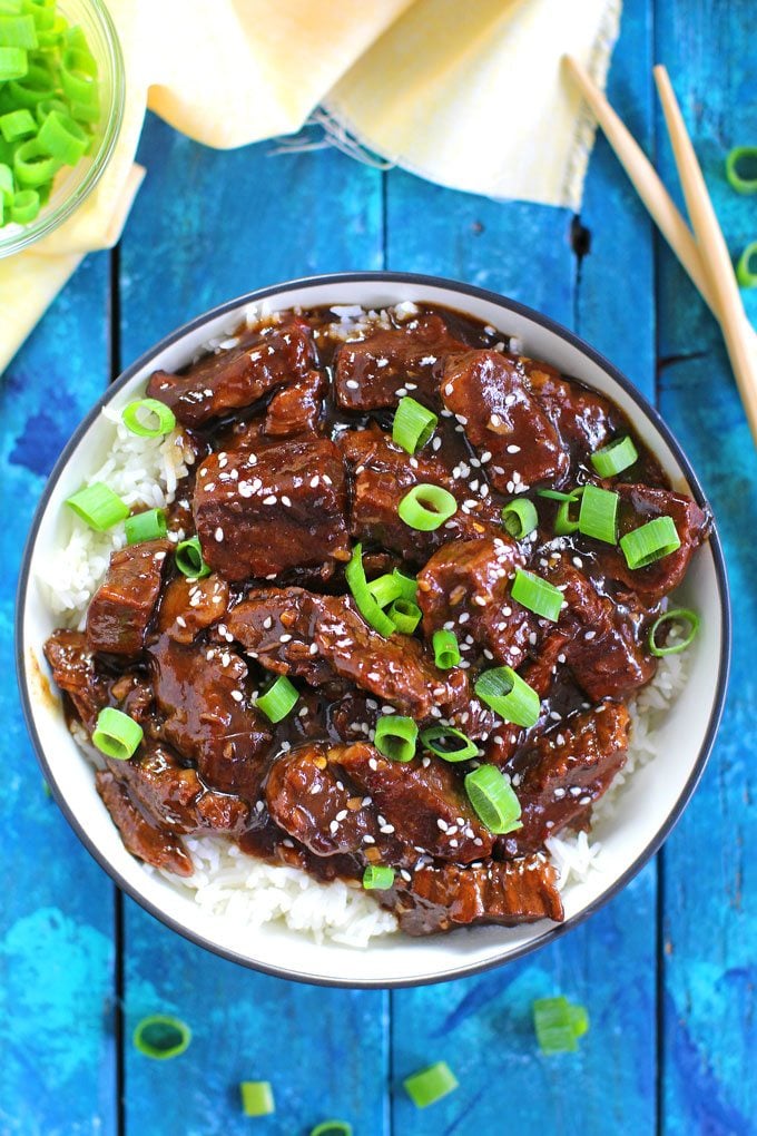 Mongolian Beef on top of rice garnished with diced green onions