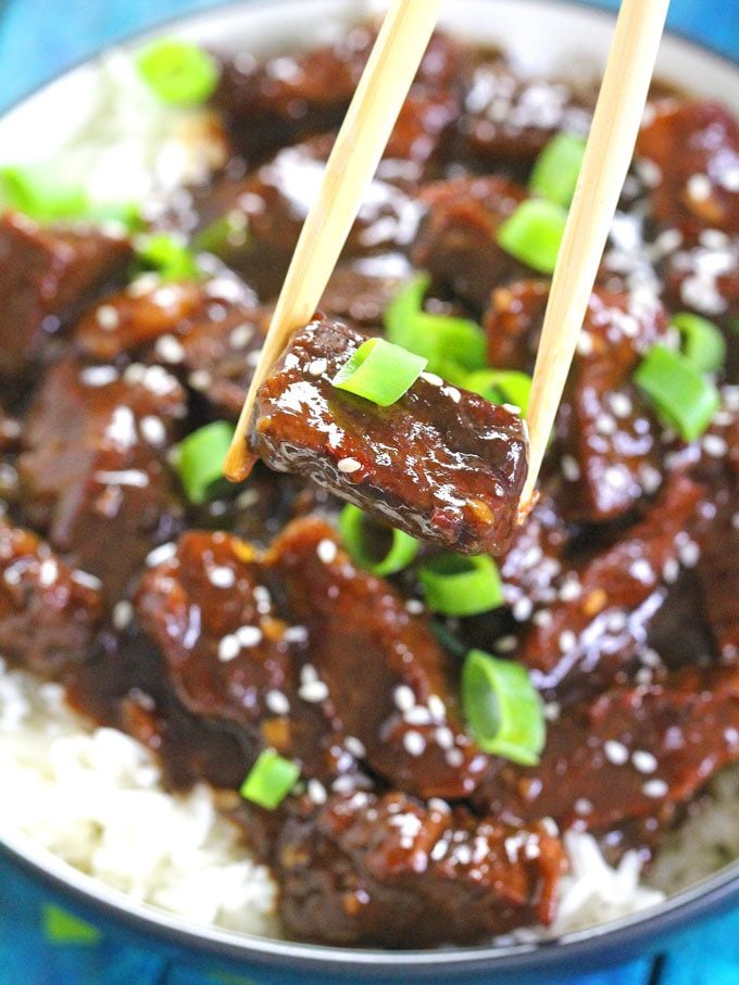 chopsticks holding a piece of Mongolian Beef