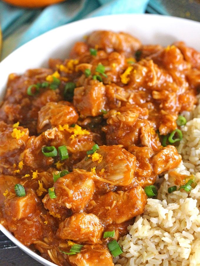 homemade Orange chicken with rice topped with chopped green onions