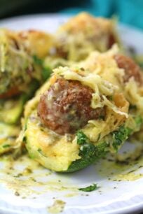 Meatball Zucchini Boats are stuffed with pesto, juicy meatballs and topped with Alfredo sauce and lots of cheese, for a quick and delicious dinner or easy appetizer.
