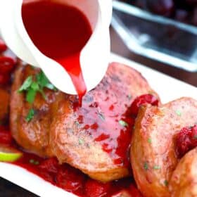 pouring cherry sauce over boneless pork chops