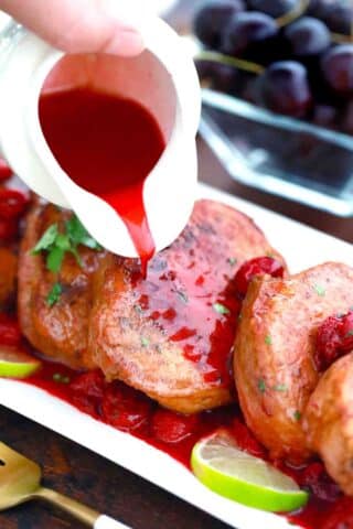 pouring cherry sauce over boneless pork chops