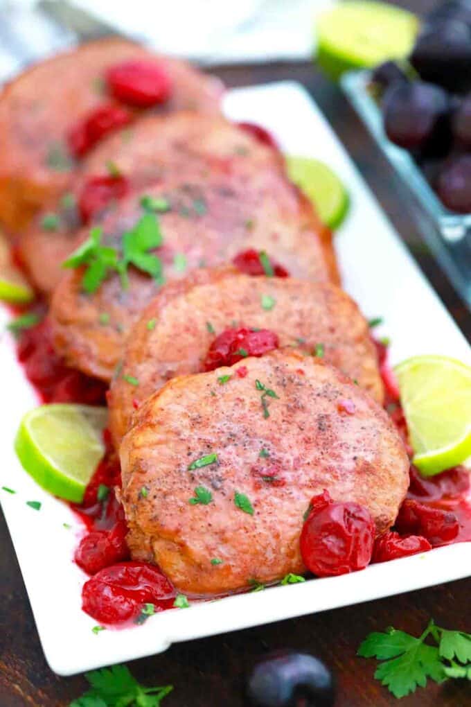 a plate with cherry pork chops and lime slices