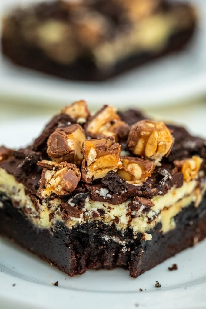 Image of slutty cheesecake brownie bars with snickers.