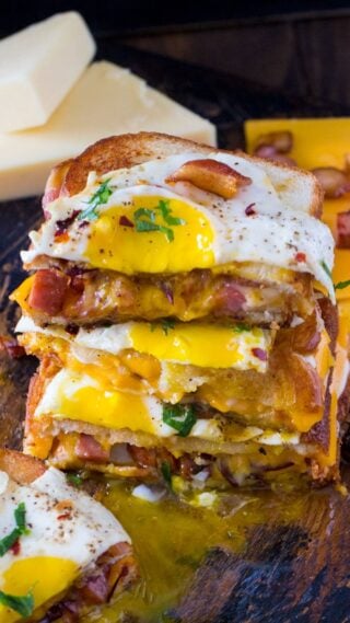 Monte Cristo Grilled Cheese sandwiches are deliciously stuffed with fried ham, bacon, cheese and topped with a perfect runny egg.