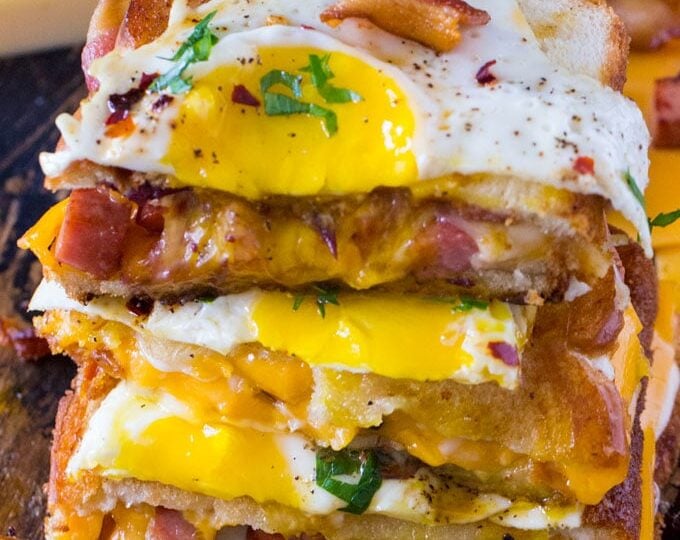 Monte Cristo Grilled Cheese sandwiches are deliciously stuffed with fried ham, bacon, cheese and topped with a perfect runny egg.