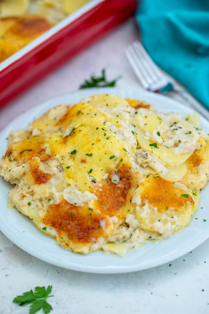 Baked potato with bechamel sauce on a white plate