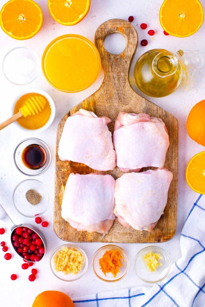 cranberry orange chicken ingredients in bowls on a white surface