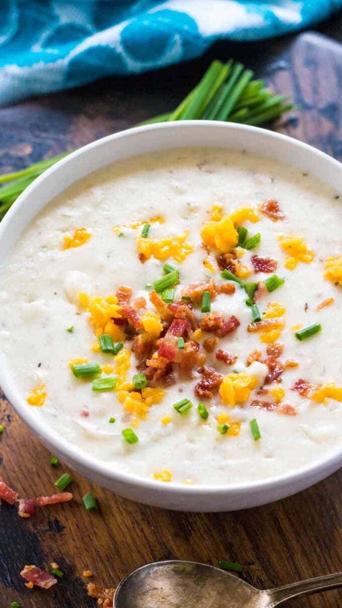 a bowl of homemade Panera bread baked potato soup topped with bacon bits shredded cheese and chives