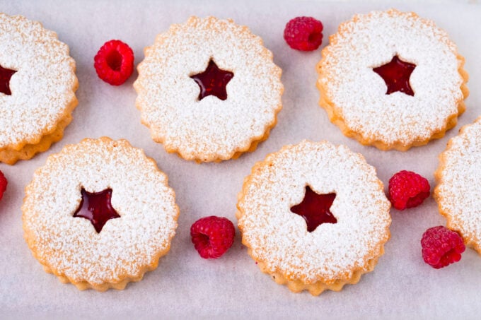 Overhead shot of raspberry Linzer cookies on a serving plate.