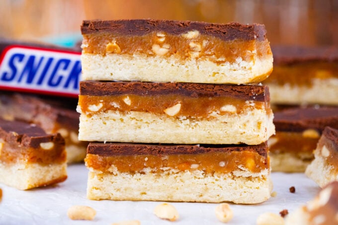 Three Snickers cookie bars stacked on top of each other.