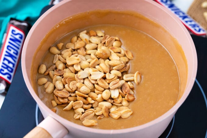 Adding peanuts to homemade caramel sauce.