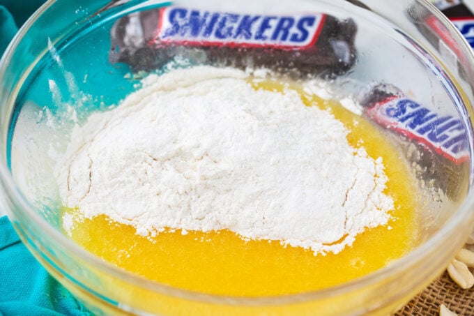Adding flour to melted butter and sugar mixture.