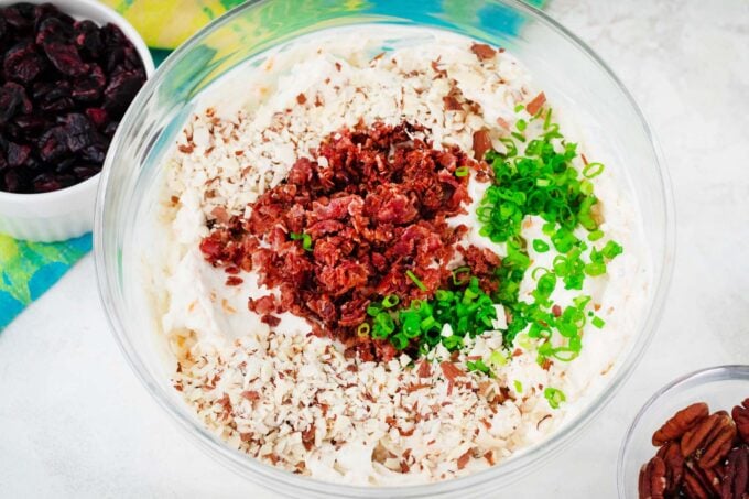 Stirring in bacon, chopped nuts, and green onions into cheese mixture.