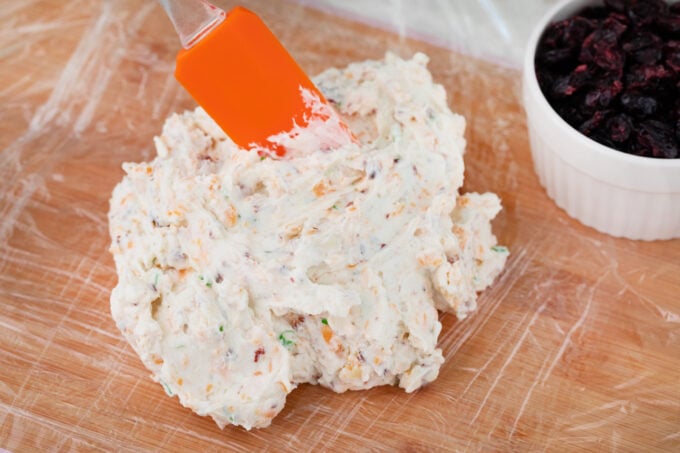 Bacon and cheese cheese ball on plastic wrap.