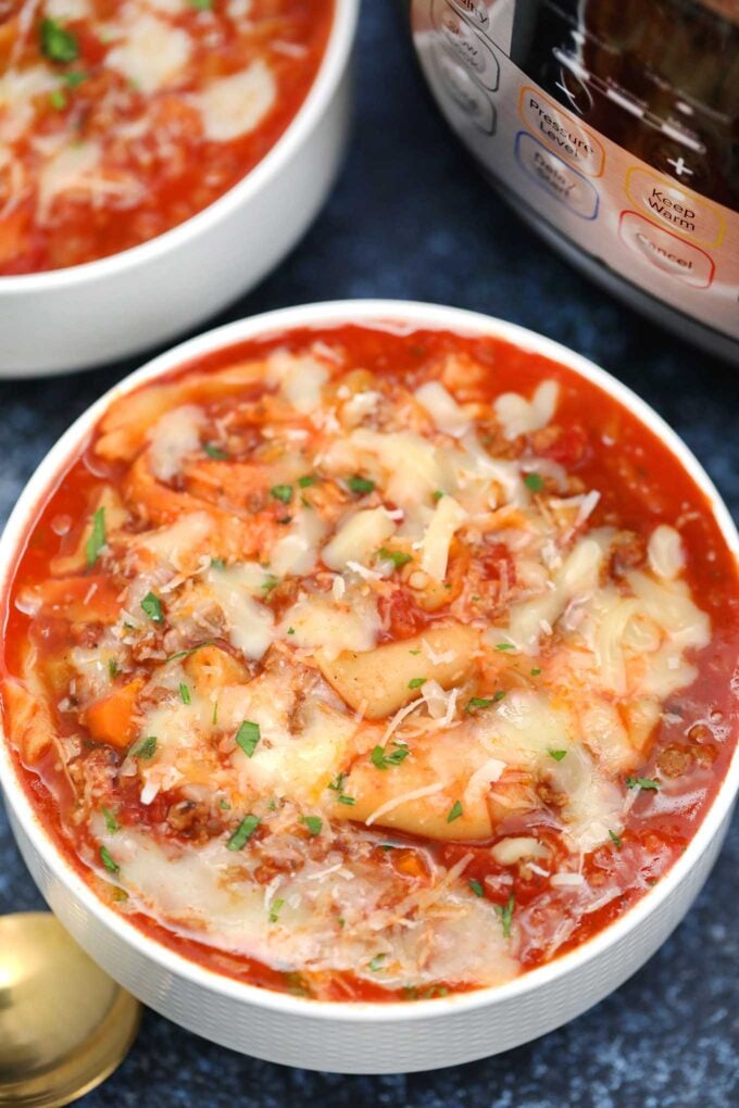 bowls of lasagna soup garnished with shredded cheese