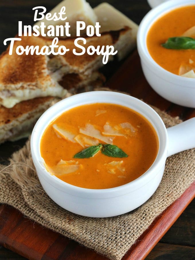 bowls of Instant Pot Tomato Soup topped with parmesan cheese and basil