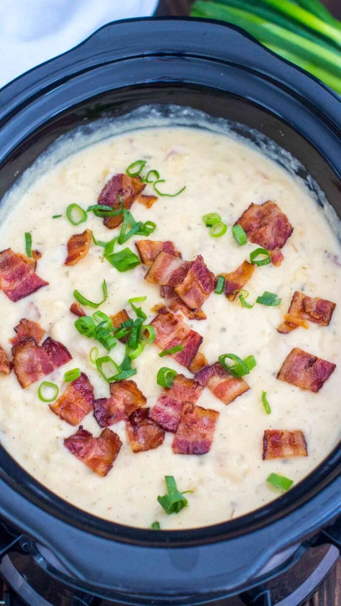 crockpot baked potato soup garnished with bacon and chopped green onion