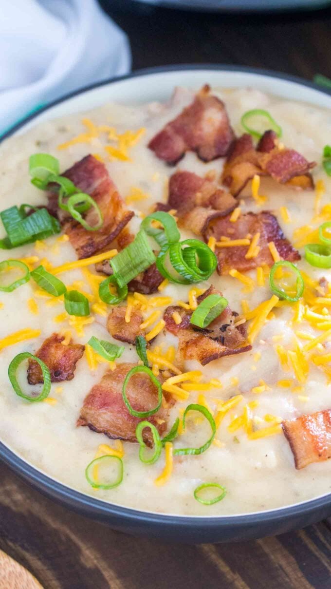 bowl of potato soup garnished with cheese bacon and chopped green onions