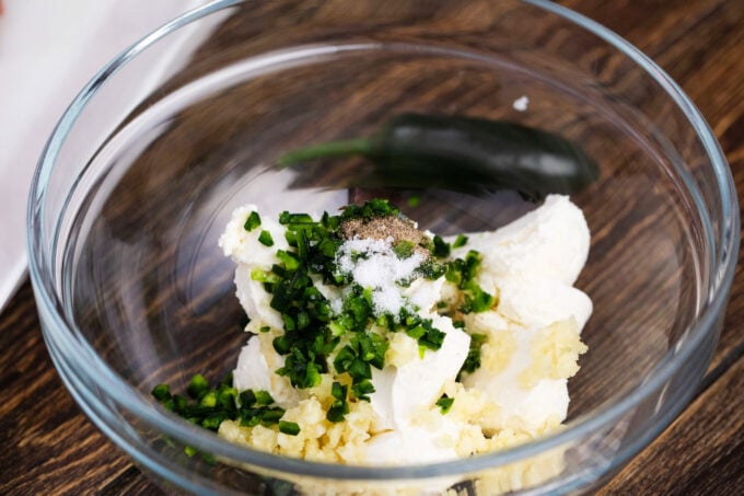 Cream cheese with garlic and jalapeños in a bowl.