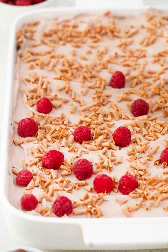 topping a chocolate cake with fresh raspberries